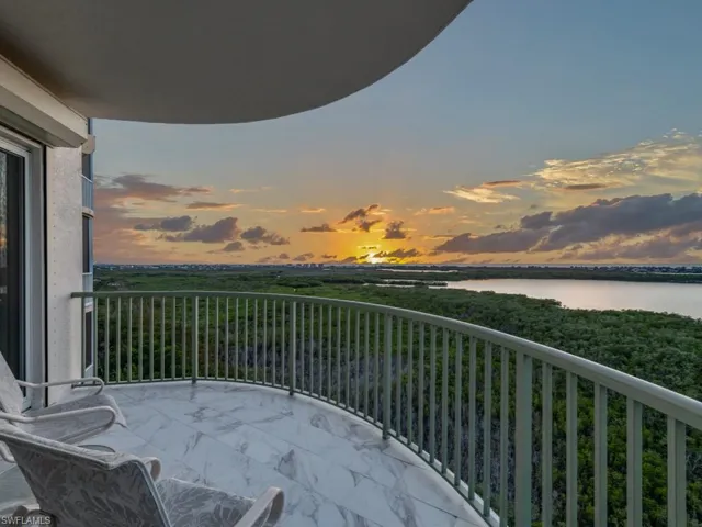 Balcony at dusk featuring a water view