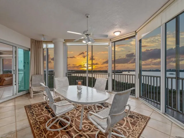 Sunroom featuring ceiling fan and a water view
