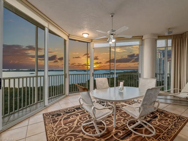 Sunroom with ceiling fan and a water view