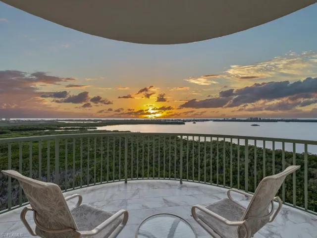 Balcony at dusk featuring a water view