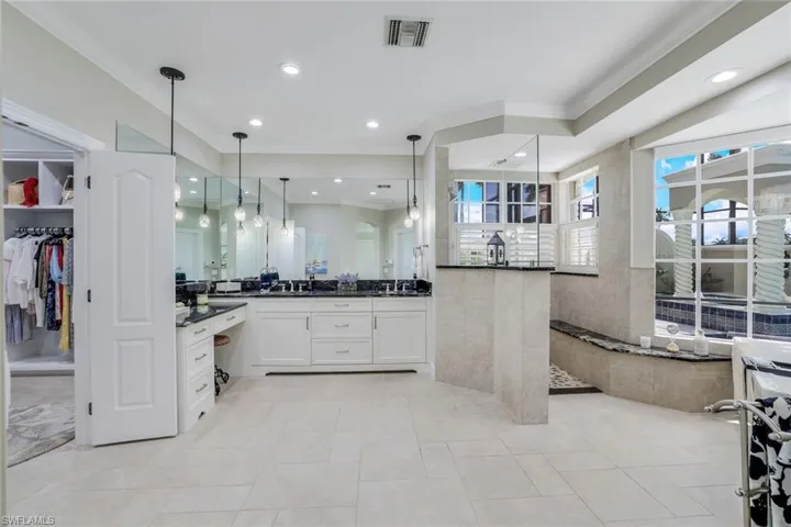 Dual comfort height granite countertop vanities with a dressing area. Walk in shower. Huge custom closet.