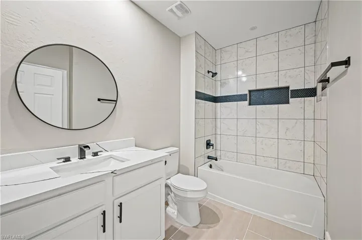 Bathroom with vanity, shower / bathing tub combination, toilet, and visible vents