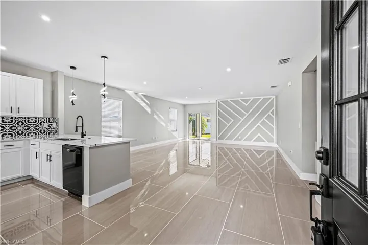 Kitchen with visible vents, open floor plan, dishwasher, a peninsula, and a sink