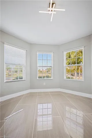 Unfurnished room with tile patterned flooring, a ceiling fan, and baseboards