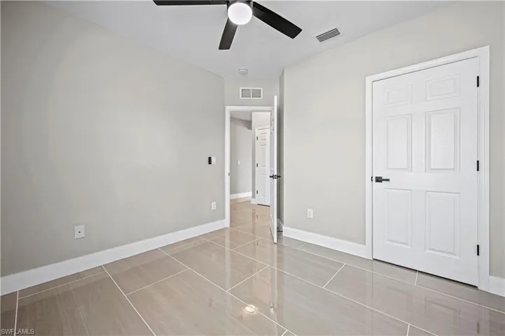 Unfurnished bedroom with visible vents, a ceiling fan, and baseboards