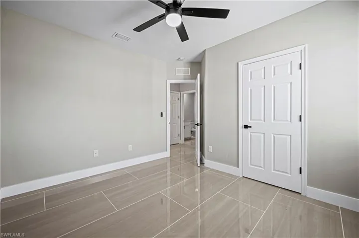 Unfurnished bedroom with visible vents, a ceiling fan, and baseboards