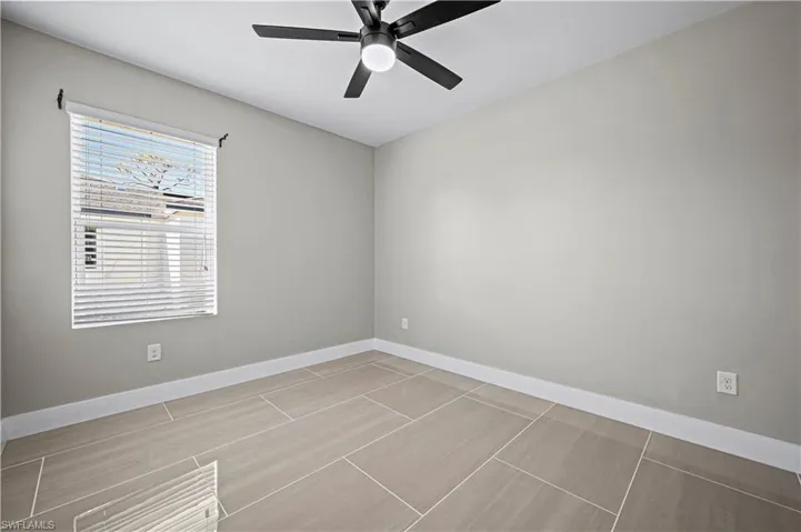 Unfurnished room featuring a ceiling fan and baseboards