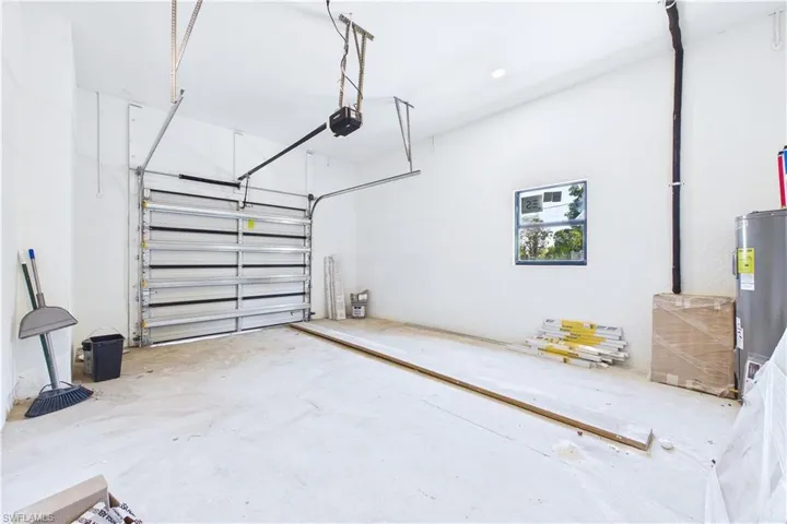 Garage featuring water heater and a garage door opener