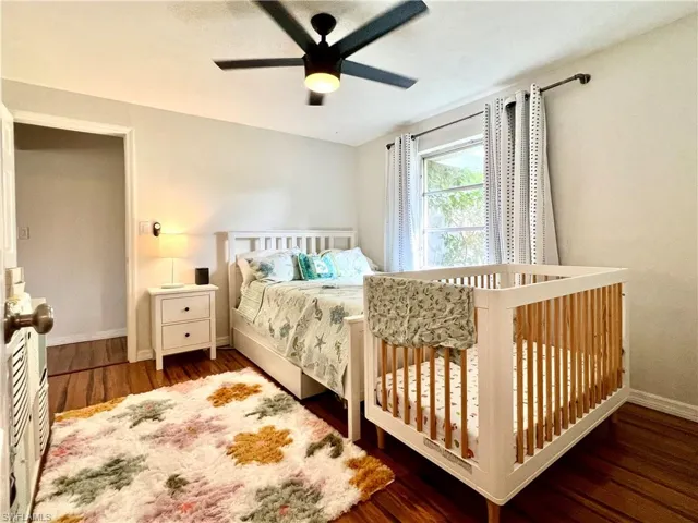 Bedroom with ceiling fan and dark hardwood / wood-style flooring