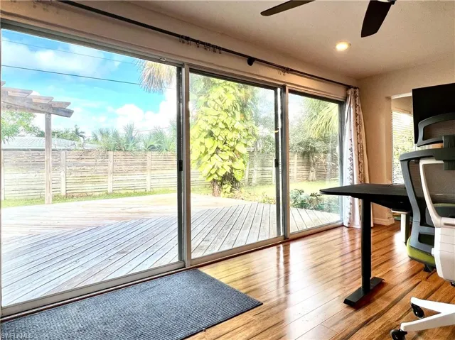 Doorway featuring ceiling fan and wood-type flooring