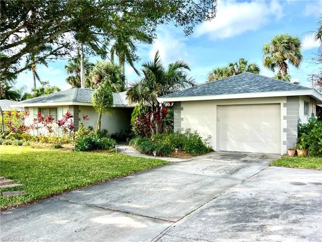 Ranch-style home with a garage and a front lawn