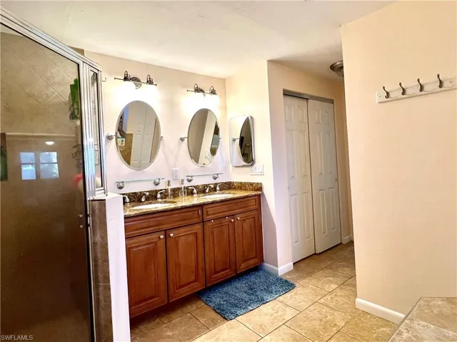 Bathroom with vanity, tile patterned floors, and an enclosed shower