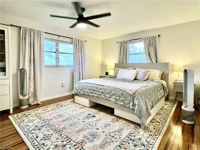Bedroom with ceiling fan and dark wood-type flooring