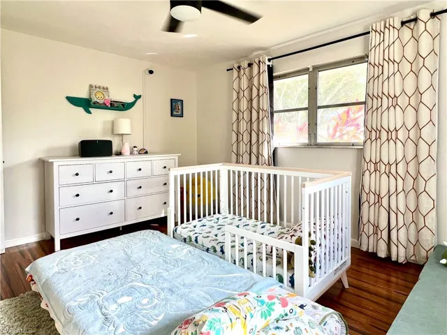 Bedroom with ceiling fan and dark wood-type flooring