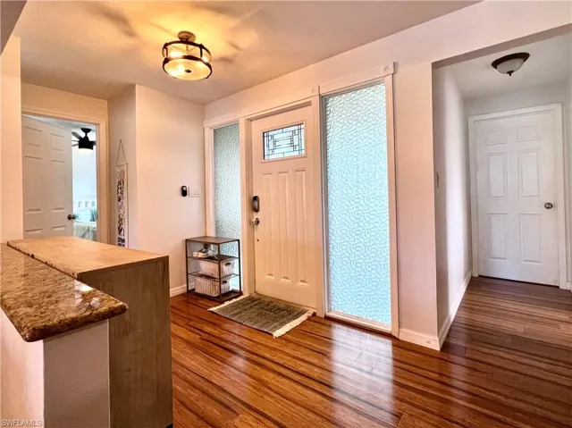 Foyer with ceiling fan and dark hardwood / wood-style flooring
