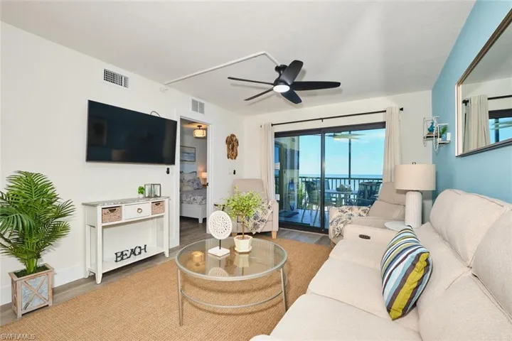Living area with wood finished floors and ceiling fan
