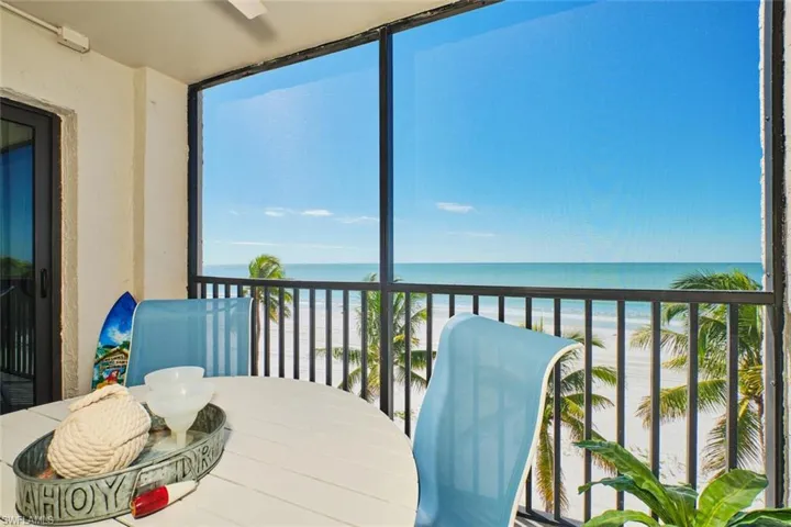 Sunroom / solarium featuring view of water and beach