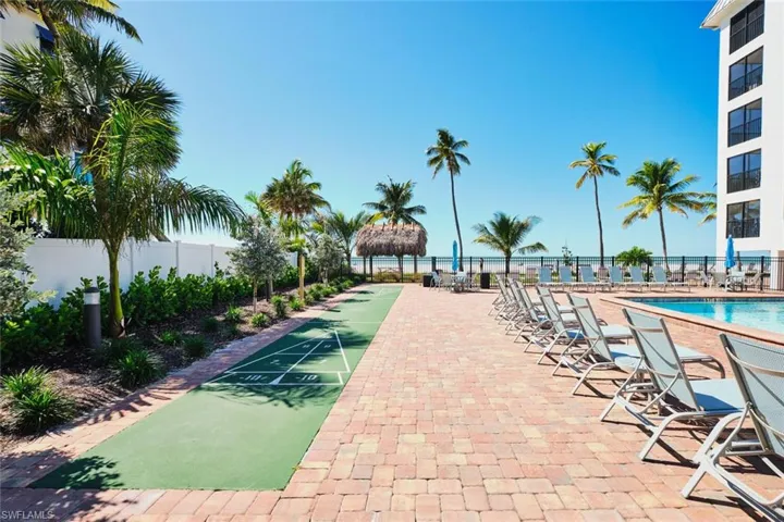 Surrounding community with shuffleboard, a swimming pool, and a patio