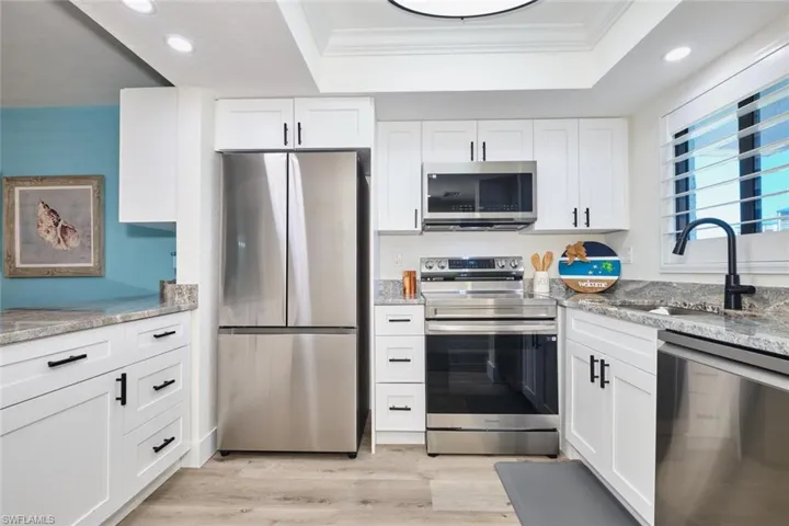 Kitchen featuring white cabinetry, appliances with stainless steel finishes, crown molding, and recessed lighting