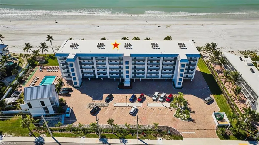 Aerial view of apartment complex and waterfront with a beach