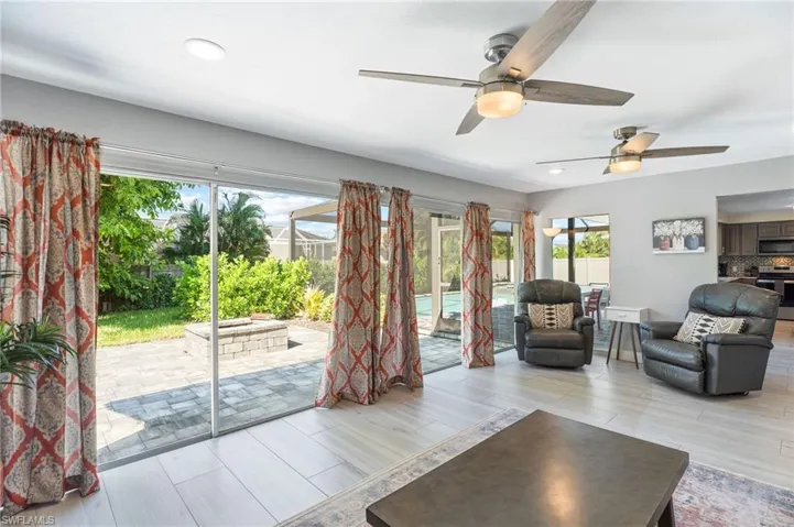 Living room featuring ceiling fan and light tile flooring