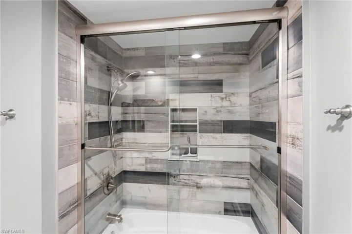 Bathroom featuring tile bath / shower combo with glass door
