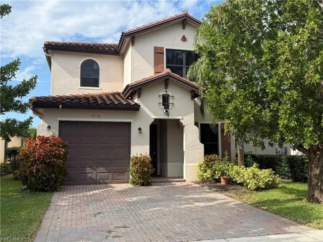 Mediterranean / spanish-style home with a tiled roof, a garage, decorative driveway, and stucco siding