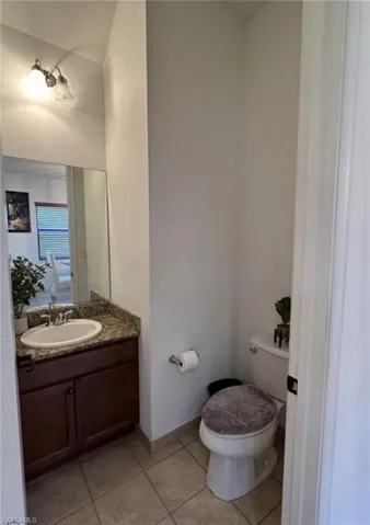 Half bathroom featuring vanity and light tile patterned flooring