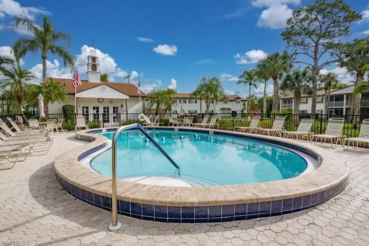 Community pool with a patio area and a residential view