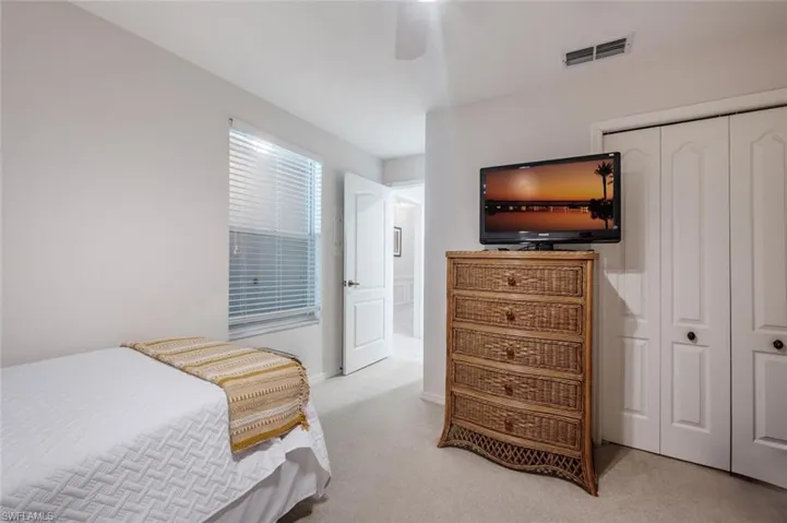 Carpeted bedroom with baseboards, visible vents, a closet, and ceiling fan