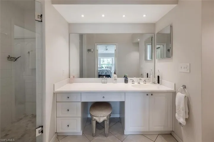 Bathroom featuring vanity, connected bathroom, tile patterned flooring, and tiled shower