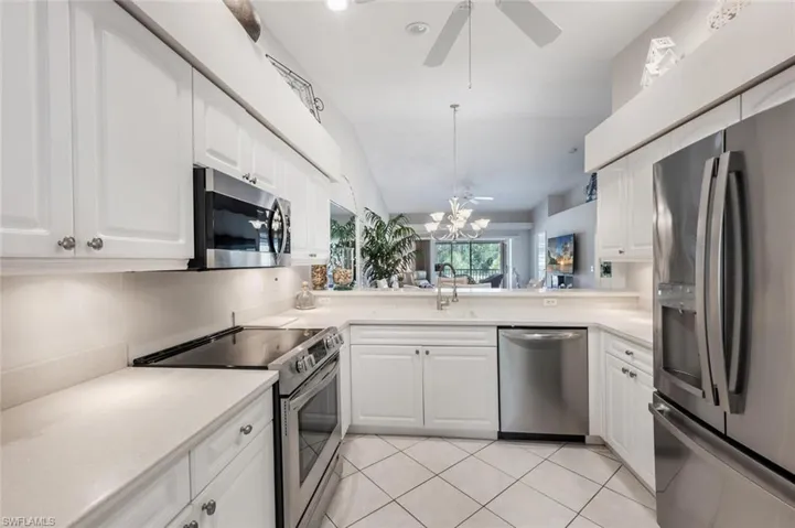 Kitchen with light countertops, light tile patterned floors, a sink, and appliances with stainless steel finishes