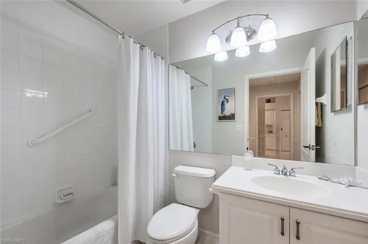 Full bath with shower / tub combo with curtain, toilet, and vanity