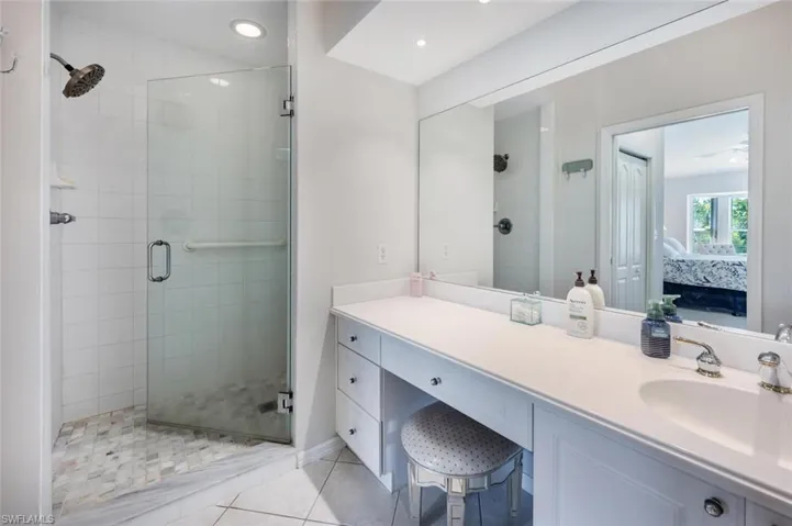 Bathroom featuring ensuite bathroom, vanity, tile patterned floors, and a shower stall