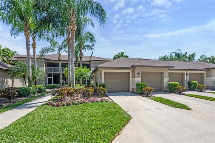 View of front of home with driveway, a front yard, stucco siding, a shingled roof, and a garage
