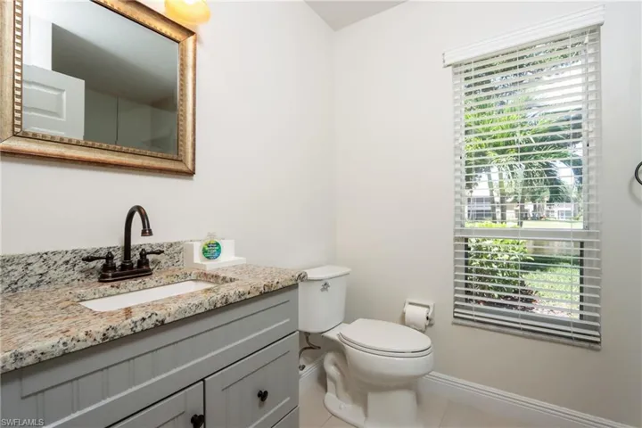 Bathroom with baseboards, tile patterned floors, vanity, and toilet