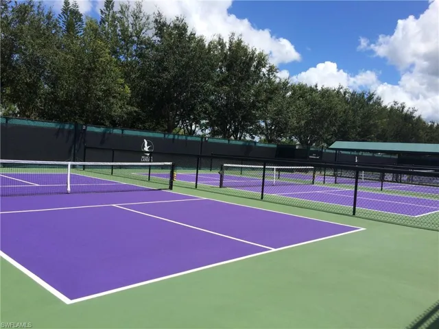View of tennis court featuring fence