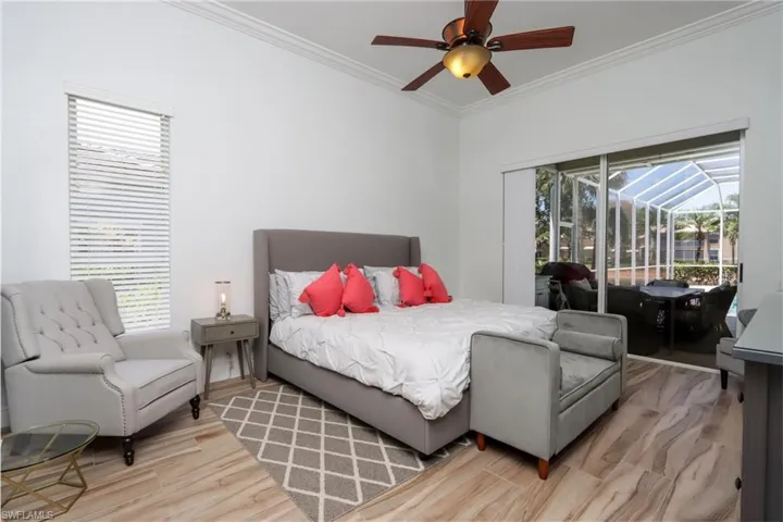 Bedroom featuring access to exterior, crown molding, multiple windows, light wood-style floors, and ceiling fan