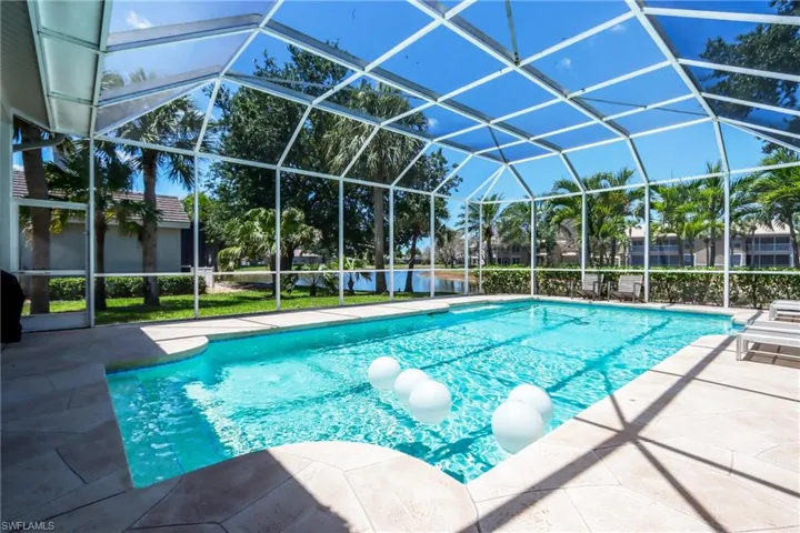Outdoor pool with a patio area and glass enclosure