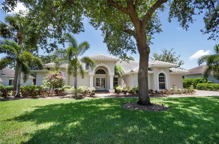 Mediterranean / spanish-style house with french doors, stucco siding, a front yard, and a tiled roof