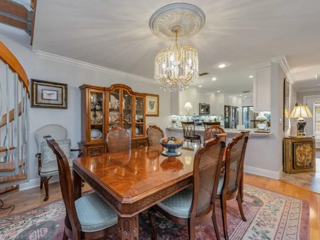 Dining area featuring light wood finished floors, a chandelier, crown molding, and recessed lighting