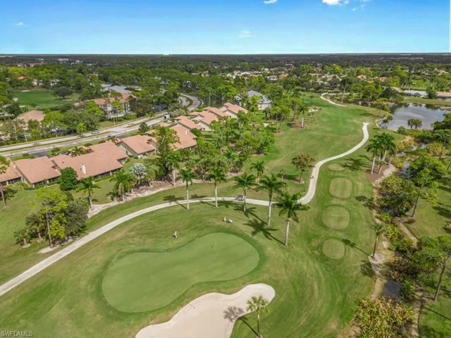 Aerial view of property's location featuring a local golf course and nearby suburban area