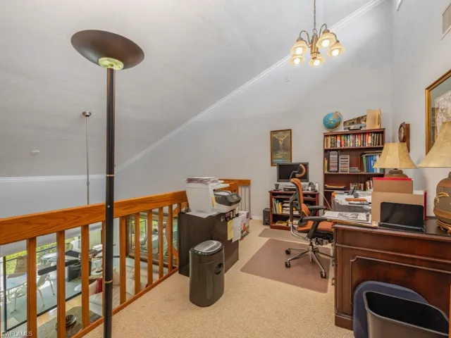 Office area with ornamental molding, carpet, a chandelier, and vaulted ceiling