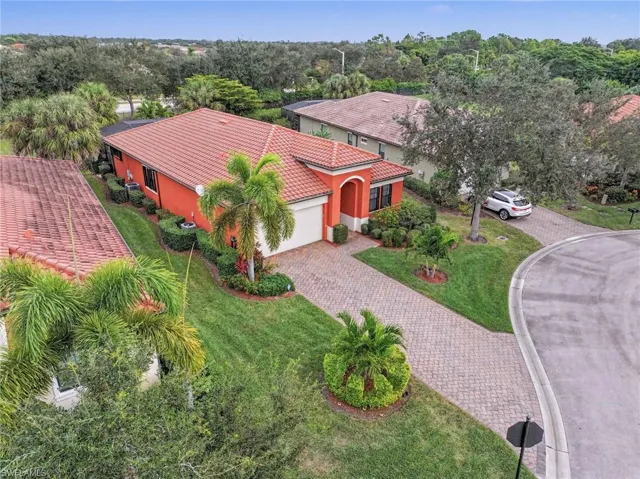 Aerial view of property and surrounding area featuring a tree filled landscape