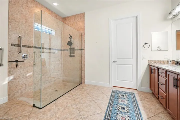 Bathroom featuring vanity, a stall shower, and light tile patterned flooring