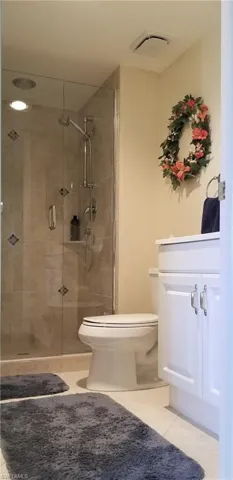 Guest bath with tiled shower, glass door and spacious vanity.