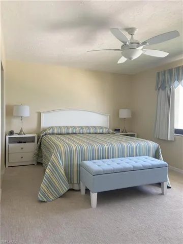 Bedroom with a ceiling fan, carpet flooring, a textured ceiling, and baseboards
