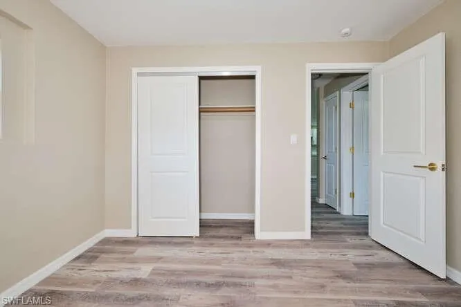 Unfurnished bedroom featuring a closet and light wood-type flooring