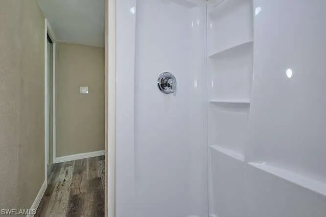 Bathroom with walk in shower and hardwood / wood-style flooring