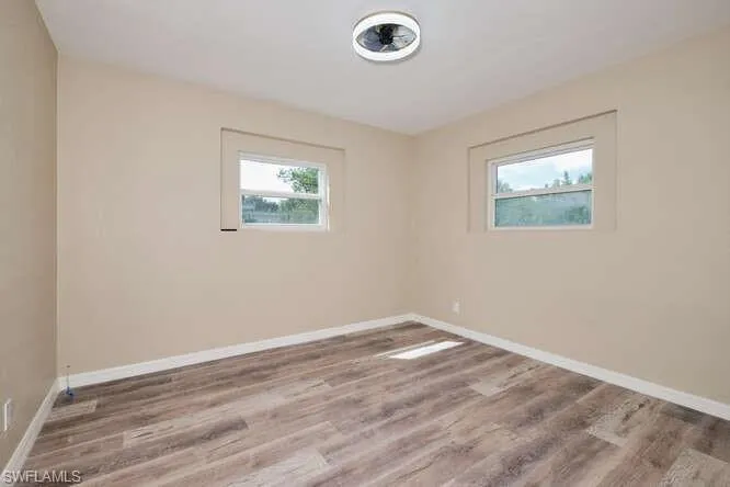 Empty room featuring plenty of natural light and hardwood / wood-style floors